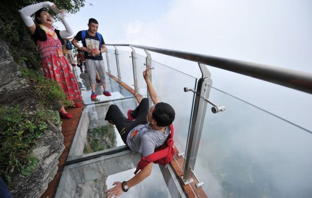 People take photos on the glass walkway on Tianmen Mountain (1 Aug 2016)