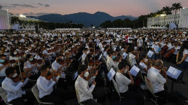 Integrantes del Sistema Nacional de Orquestas de Venezuela tocan durante un intento de ingresar al Libro Guinness de los Récords para la orquesta más grande del mundo, con más de 12.000 músicos, en la Academia Militar del Ejército Bolivariano en el Complejo Militar Fuerte Tiuna, en Caracas. , el 13 de noviembre de 2021.