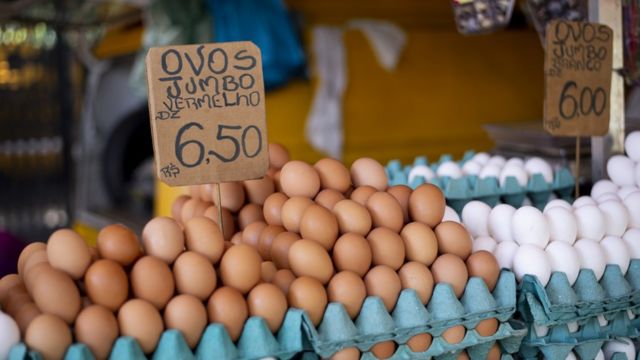 Ovos vermelhos e brancos com placas de preço em português