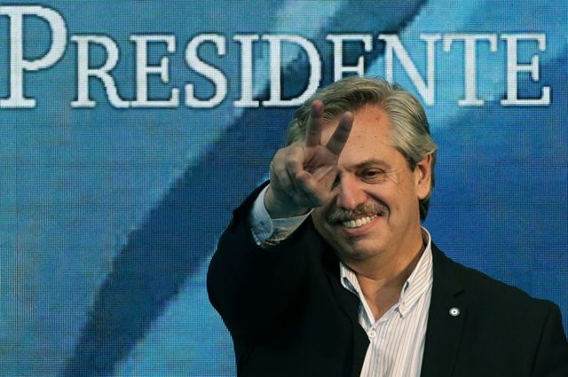 Alberto Fernández con un cartel atrás que dice "presidente"