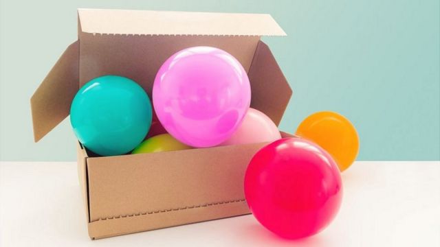 Balões coloridos em uma caixa de papelão