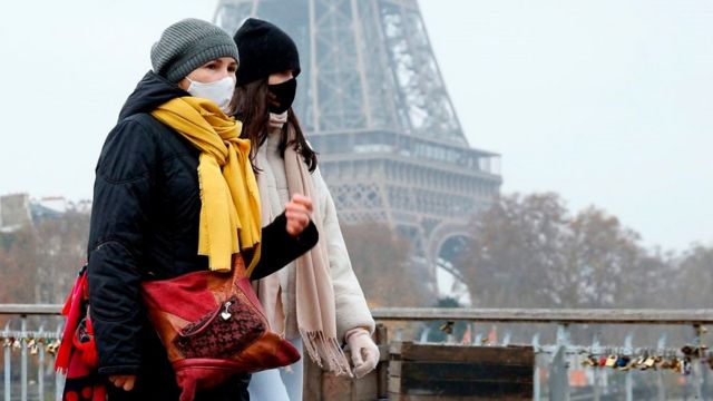 People walk past Eiffel Tower