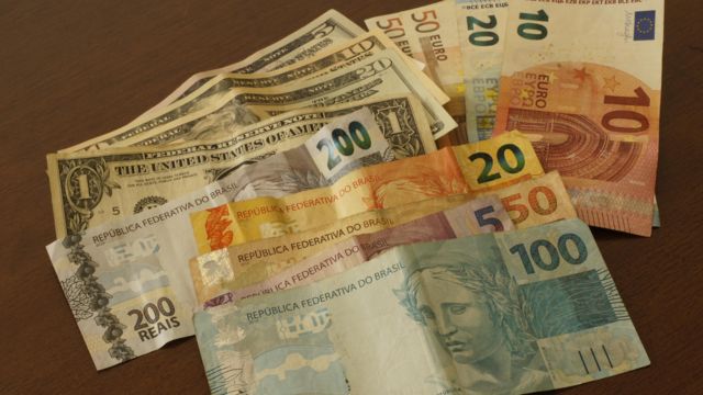 Notas de dólar, real e euro