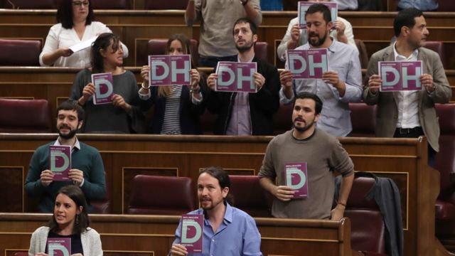 Parlamentarios con carteles con las letras DH piden respeto a los derechos humanos en el parlamento en Madrid