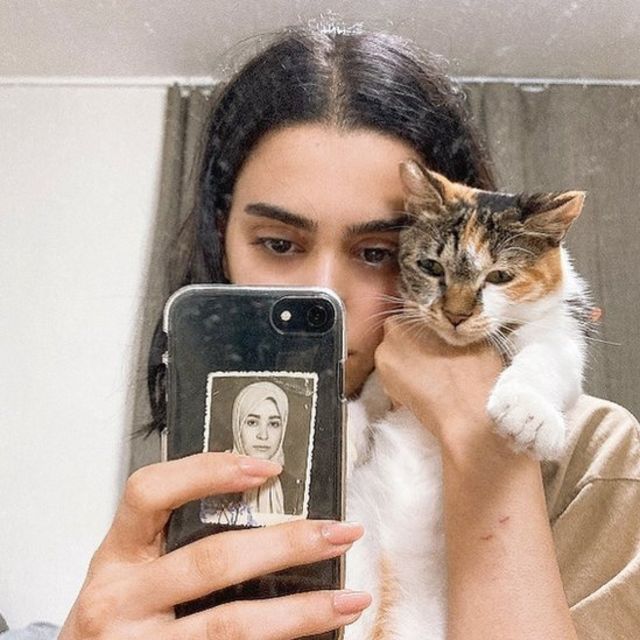 With her cat Coco and a photo of her mother