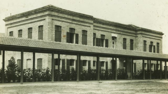 Foto em preto e branco mostra fachada de prédio