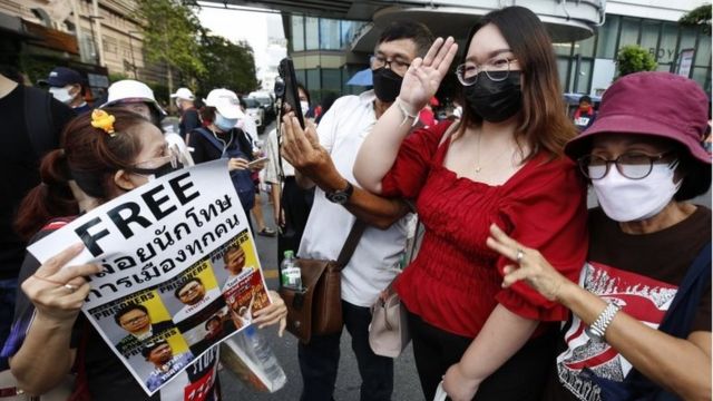 Thai pro-democracy activist Panusaya "Rung" Sithijirawattanakul (2-R) flash three-finger salutes and pose for a photo as they gather to protest against the lese majeste law in Bangkok, Thailand, 31 October 2021.