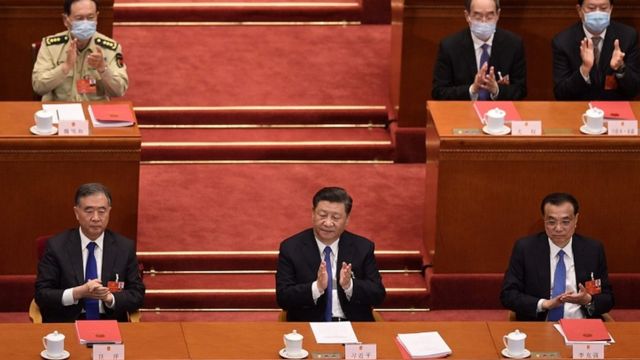 China's President Xi Jinping (c) applauds after the vote during the closing session of the National People's Congress at the Great Hall of the People in Beijing on May 28, 2020