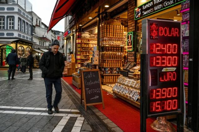 رجل يمشي بجانب محل صرافة في اسطنبول