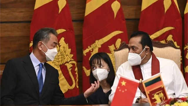 Chinese Foreign Minister Wang Yi (left) speaks with Sri Lanka's Prime Minister Malinda Rajapakse during an official meeting in Colombo on January 9, 2022.