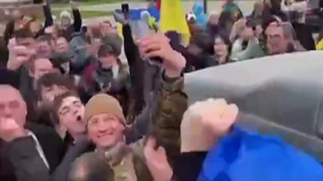  người dân Ukraine ăn mừng cùng các binh sỹ trên Quảng trường Tự do của thành phố Kherson. 
