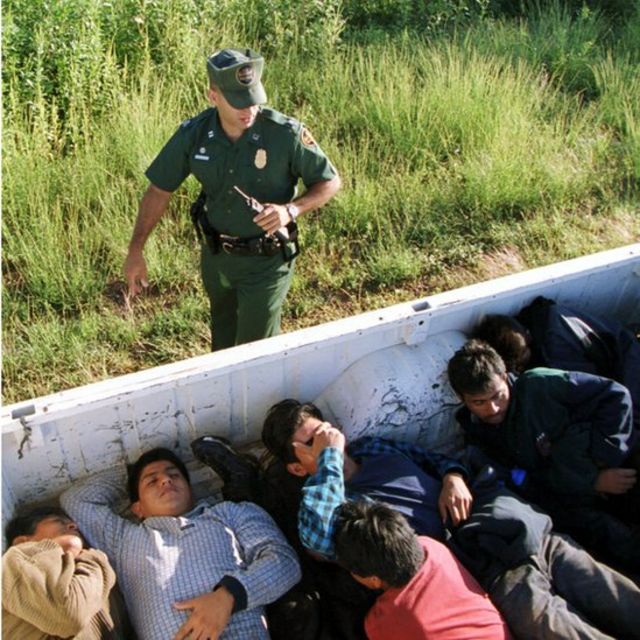 Un agente fronterizo con migrantes