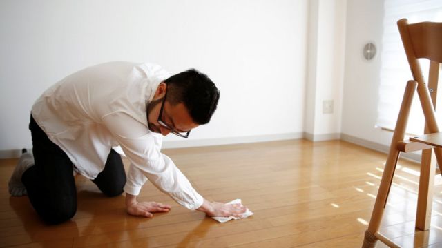 El minimalista Fumio Sasaki usa una toalla mojada para limpiar el piso de su habitación, en Tokio.
