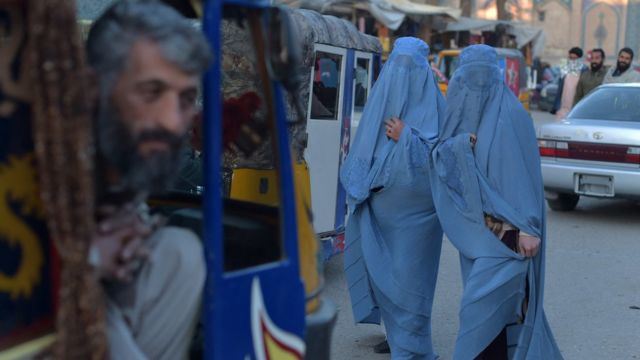 Afghan women wearing blue burqas on busy streets