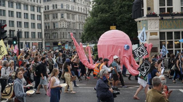 Pulpo títere rosa gigante marchando por la calle en Londres.