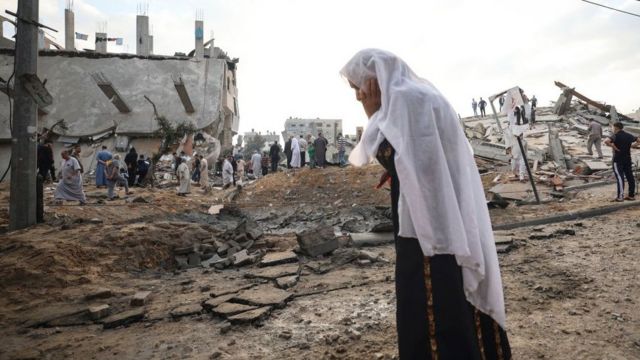 Una mujer en un sitio dañado por bombas en Gaza