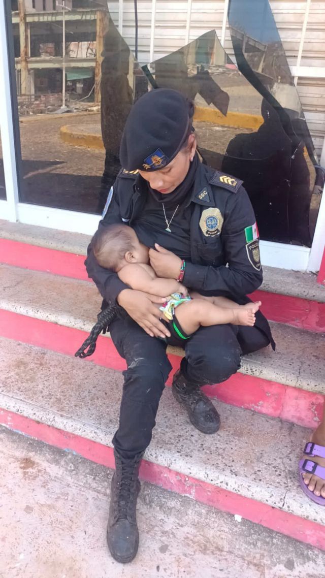 Agente policial amamantando a bebé.