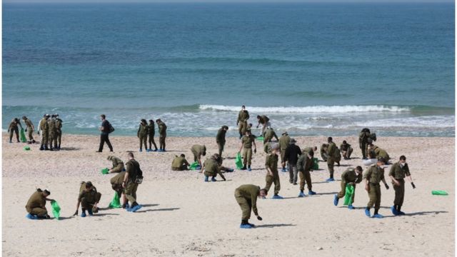 جنود إسرائيليون ينظفون شاطئا ملوثا