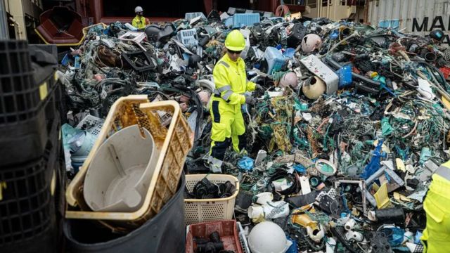 Tripulação da Ocean Cleanup separando o plástico no convés de um navio após uma extração de lixo