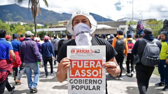 Uno de los manifestantes ecuatorianos en Quito muestra la portada de un periódico comunista universitario
