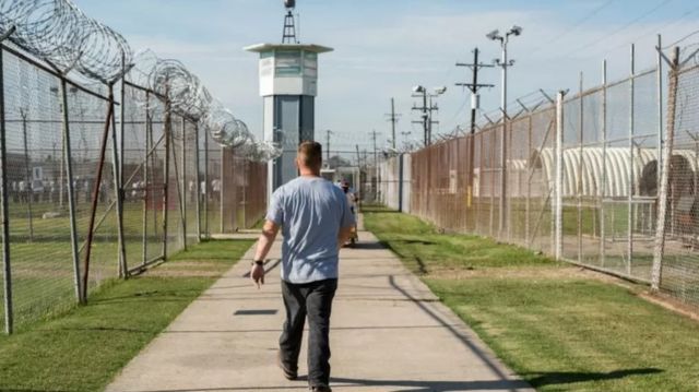 Un homme marchant dans le couloir d'une prison.