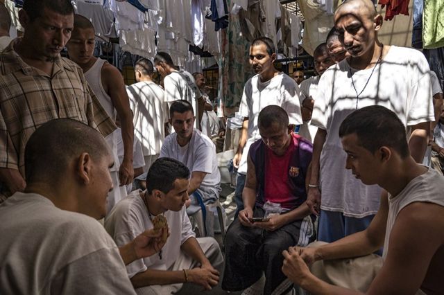 Inmates play cards while others watch, at the Chalatenango Penal Center, El Salvador. November 7, 2018.