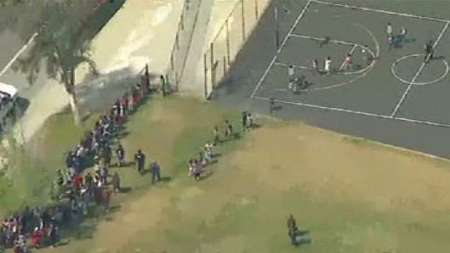 Aerial footage of children being evacuated from a primary school in San Bernardino, California, following a shooting, 10 April 2017