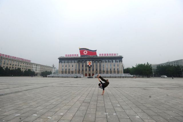 Calvin Sun em frente a edifício na Coreia do Norte