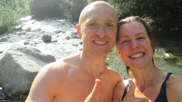 Dan and Esther give up a thumbs up after swimming in a river