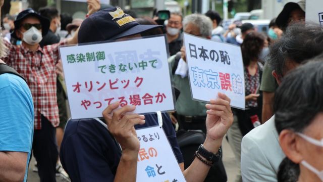 抗議民眾手持標語「確診持續擴大下辦奧運是日本之恥」。