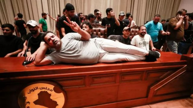 Ас-Садрчылардын бири парламент спикеринин столуна жатып алып сүрөткө түштү