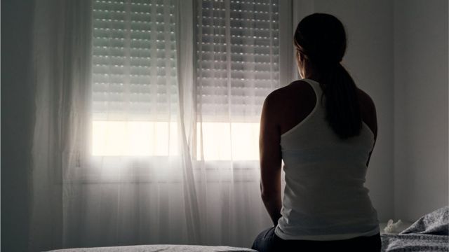 Mujer frente a una ventana.