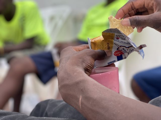 José, un haitiano de 15 años que vive en la calle, come una galleta en la sede de Caminante en Boca Chica, República Dominicana, en mayo de 2023.