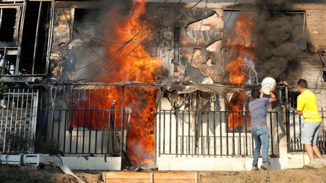 Dois homens tentam apagar um incêndio em Viña del Mar