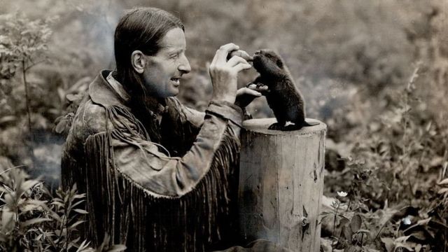 El polémico naturalista Grey Owl dando leche con una botella a un castor bebé