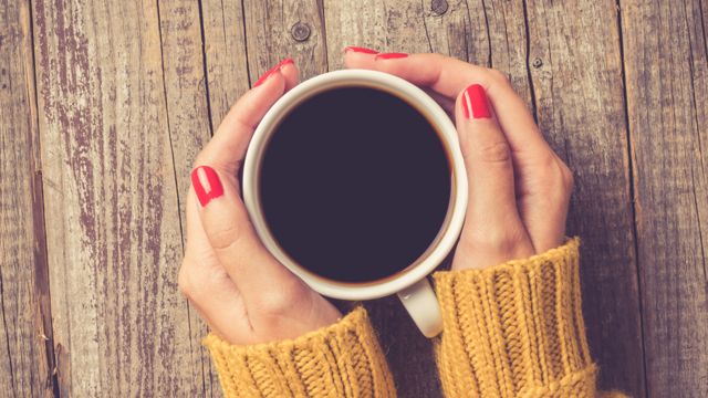 Manos de mujer en torno a una taza de café