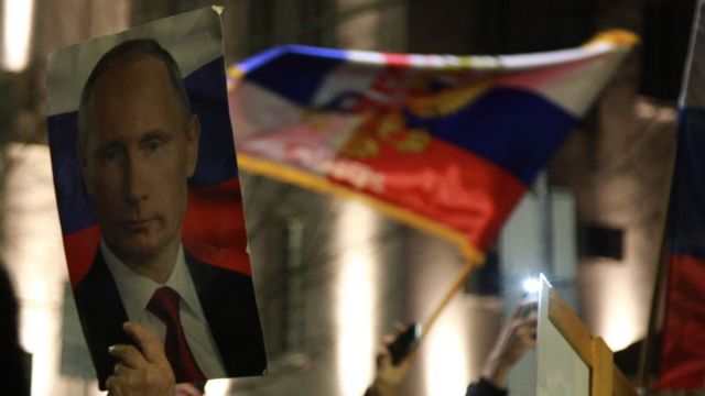 أشخاص يلوحون بالأعلام الروسية والصربية ويحملون ملصقات لفلاديمير بوتين خلال مسيرة نظمتها المنظمات اليمينية الصربية لدعم الهجمات الروسية على أوكرانيا ، في بلغراد، 4 مارس 2022