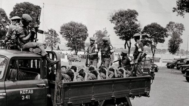 Sejumlah anggota militer Indonesia menangkap dan membawa belasan pemuda yang diduga menjadi anggota PKI di Jakarta, 10 Oktober 1965.