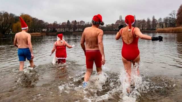 Members of the Berliner Seehunde (Berlin seals) swimming club take their traditional Christmas bath at the Orankesee lake