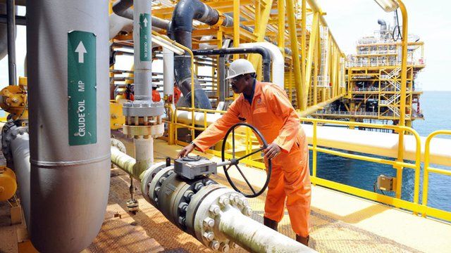 Homem opera equipamento em plataforma de exploração de petróleo