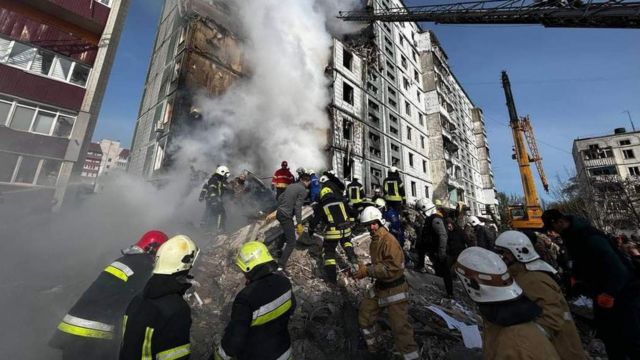 Rescuers work to clear rubble from a collapsed building