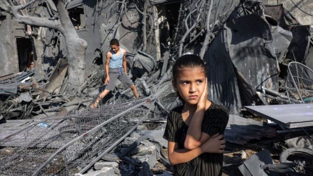 パレスチナ自治区ガザ地区南部ラファでイスラエル軍の空爆後、がれきのそばに立つ少女（10月31日）