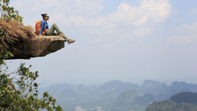 A young woman enjoying the view at a mountain peak in Asia