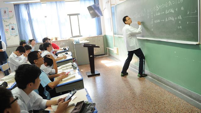 Un alumno resuelve un problema matemático en frente de la clase en la escuela estatal Shanghái Número Ocho.