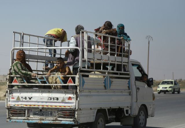 Civis curdos tentam escapar de áreas bombardeadas na Síria, em 18 de agosto