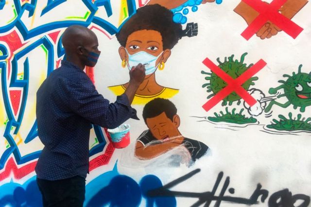 Congolese artist Chris Shongo paints a mural in Kinshasa.