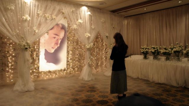 A woman visits a memorial shrine to the late Hong Kong film star and singer Leslie Cheung at the Mandarin Oriental hotel in Hong Kong, 01 April 2004, the location from where the 46-year-old star leapt to his death from the 24th floor one year before
