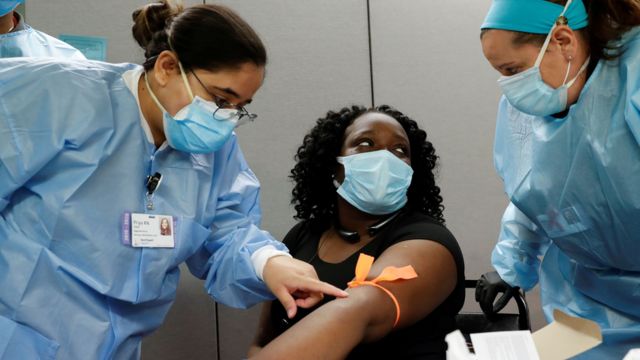 Nurses take blood from the arm of a woman