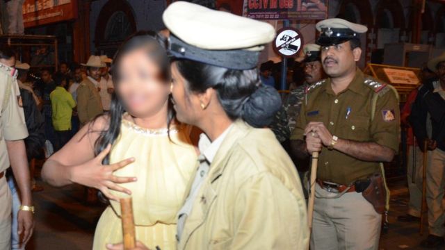 ক্রন্দনরত এক মহিলা পুলিশের সাহায্য চাইছেন