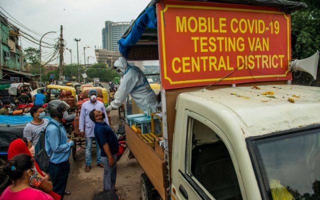 A health worker wearing protective suit takes a nasal swab from a man to test for COVID-19 coronavirus.